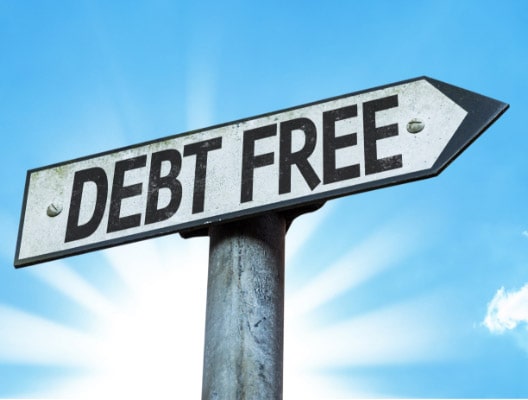A road sign with the words "DEBT FREE" against a bright blue sky with sunbeams.