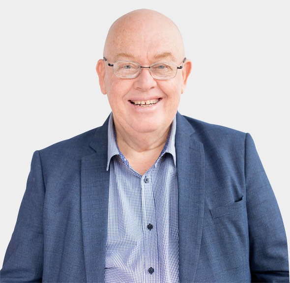 A smiling bald man wearing glasses, a blue blazer, and a checkered shirt is seen against a plain white background, ready to provide part-time CFO services in Southeast Queensland.